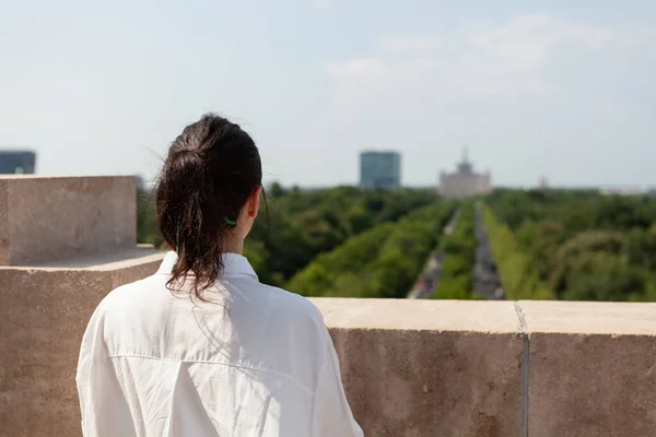 Женщина-туристка, стоящая на крыше здания, наслаждается панорамным видом — стоковое фото