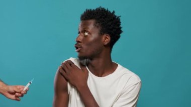 Koronavirüse karşı genç bir adamı aşılamaya hazırlanan doktorun elleri