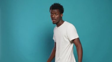 Afrikalı Amerikalı adam kamerayı parmaklarıyla işaret ediyor.