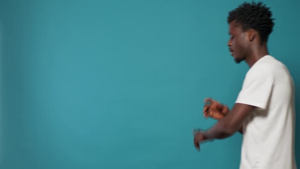 Hombre afroamericano mirando la cámara y frotando la barbilla — Vídeos de Stock