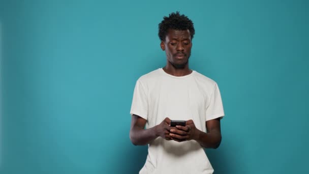 Zmatený muž používající smartphone pro textové zprávy — Stock video