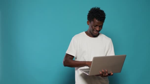 Afrikansk amerikan man använder laptop för underhållning — Stockvideo