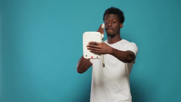 Leikkisä mies vitsailee ottaa selfiet retro lankapuhelin — kuvapankkivideo