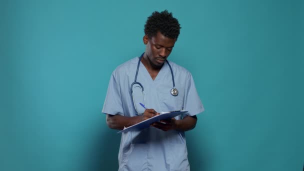 Man working as nurse and writing on medical paper — Stock Video