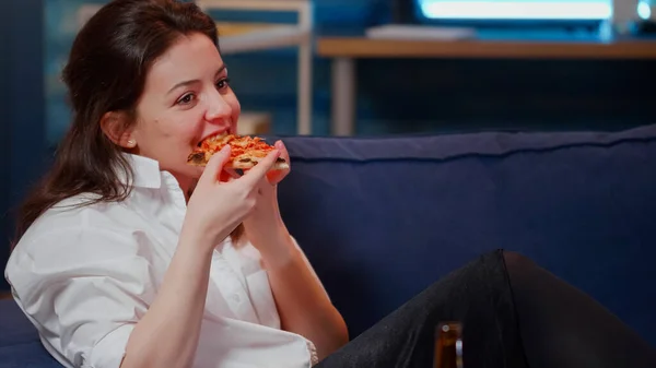 Adultos jóvenes disfrutando de rebanadas de pizza y cerveza sentados en el sofá — Foto de Stock