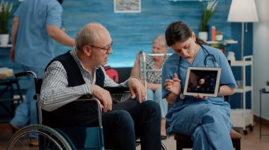 Engelli hasta dijital tablette virüs animasyonuna bakıyor