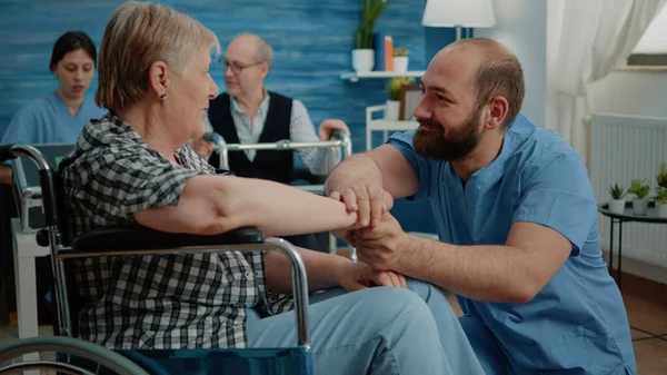 Чоловік медсестра втішає пенсіонерів з інвалідністю — стокове фото