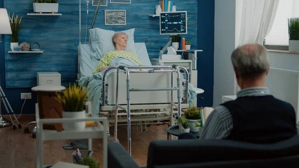 Kranker Rentner sitzt im Krankenhausbett — Stockfoto
