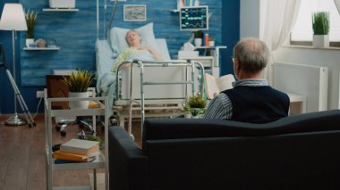 Yaşlı adam hasta kadına yardım etmeleri için doktor ve hemşire çağırıyor.