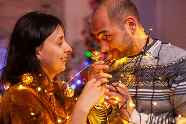 Mutlu evli çift Noel ağacı ışıklarında mahsur kalıyor. — Stok fotoğraf