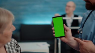 Hemşireyi dikey olarak yeşil ekranlı telefonu gösterirken kapat