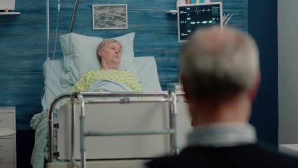 Женщина с болезнью, лежащая на больничной койке с капельницей — стоковое видео