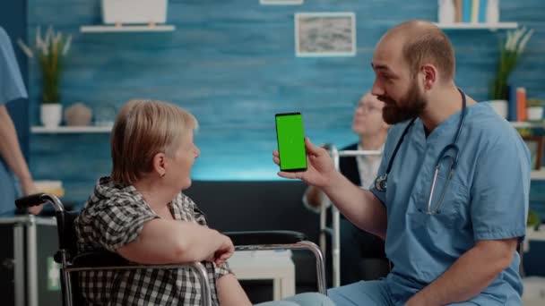 Homem enfermeira segurando tela verde no smartphone — Vídeo de Stock