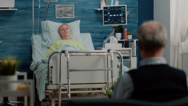 Idősebb nő feküdt a kórházi ágyon az ápolási intézményben — Stock videók