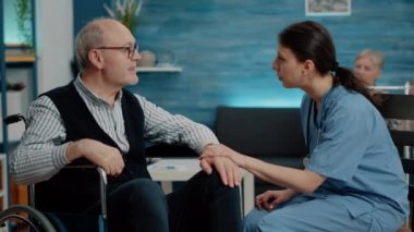 Engelli hasta hemşireden yardım alıyor.