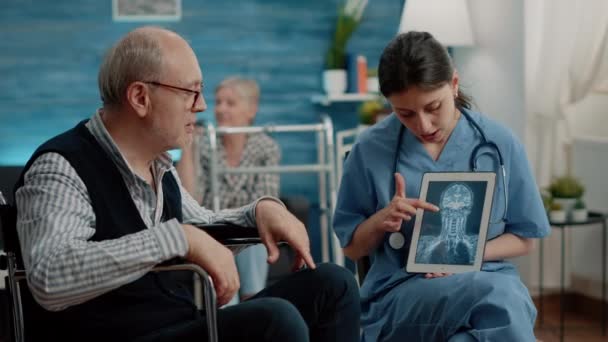 Медицинский ассистент держит планшет с рентгеновским сканированием для обследования — стоковое видео