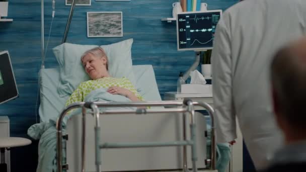 Orvosi csapat táskák és berendezések tanácsadás idős beteg — Stock videók