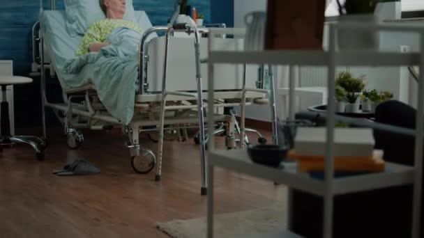 Enferma anciana acostada en cama de hospital en residencia de ancianos — Vídeos de Stock