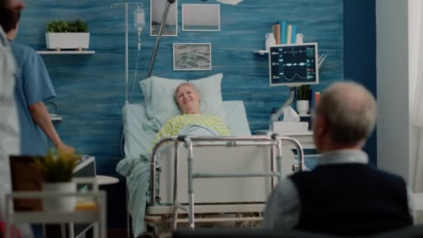 Mujer anciana con enfermedad que recibe visita del médico y la enfermera — Vídeos de Stock