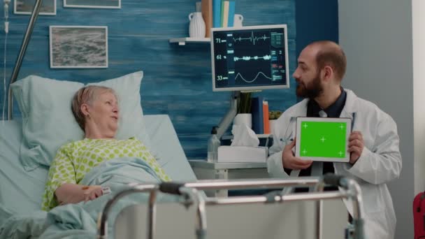 Médico con pantalla verde horizontal en tableta hablando con el paciente — Vídeo de stock