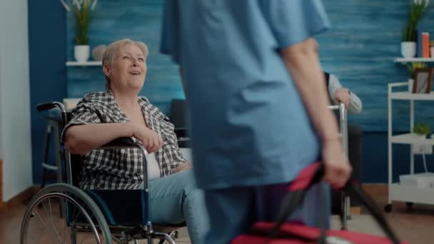 Arzthelferin unterstützt gehbehinderte Seniorin — Stockvideo