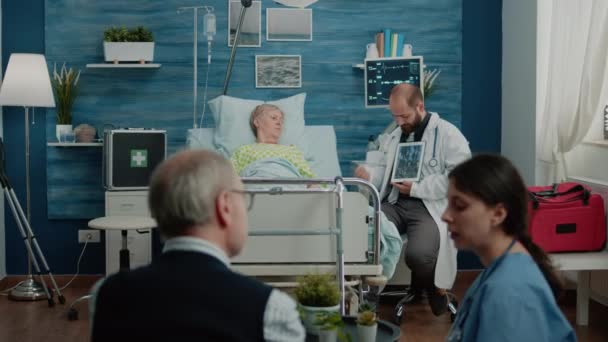 Nemocný pacient ve věku při pohledu na tabletu s osteopatií x ray — Stock video