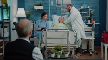 Doktor, hastane yatağında steteskop kullanıyor.