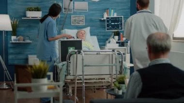 Hemşire ve doktor kıdemli hastaya bir şişe hap hazırlıyorlar.