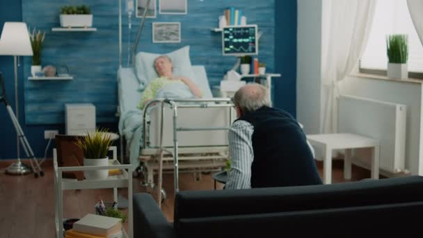 Yaşlı adam hasta kadına yardım etmeleri için doktor ve hemşire çağırıyor. — Stok video