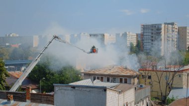 İtfaiyeciler yanan evdeki yangını söndürmek için görev başında.
