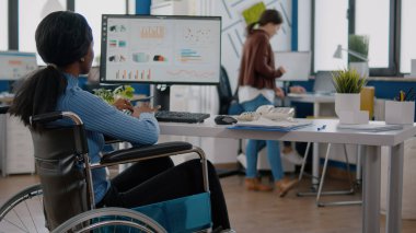 Afrika felçli kadın yöneticisi grafikleri analiz ediyor