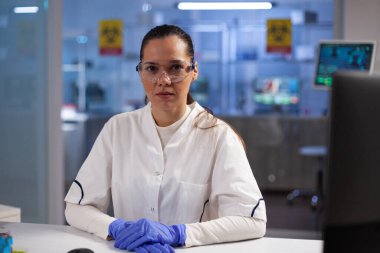 Biyokimya deneyi sırasında masada oturan doktor kadın portresi