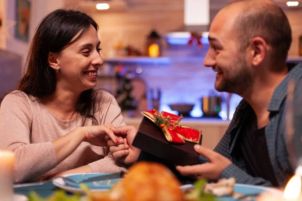 Glückliches Paar im Weihnachtsurlaub überrascht mit Weihnachtsgeschenk — Stockfoto