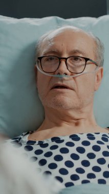 Afro-Amerikalı doktor hastane koğuşunda hasta bir hastaya tavsiye veriyor.