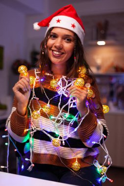 Neşeli yetişkin Noel ışıklarına dolanmış