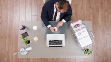 Takım elbiseli işadamının telefonda konuşurken yapışkan notlar hakkında fikirler yazmasının en üst görüntüsü