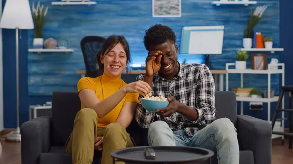 Alegre interracial casal rindo de comédia no televisão — Fotografia de Stock