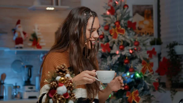 Femme caucasienne tenant tasse de café tout en utilisant appel vidéo — Photo