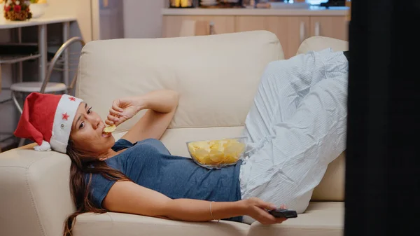 Smutna kobieta leżąca na kanapie i oglądająca telewizję — Zdjęcie stockowe