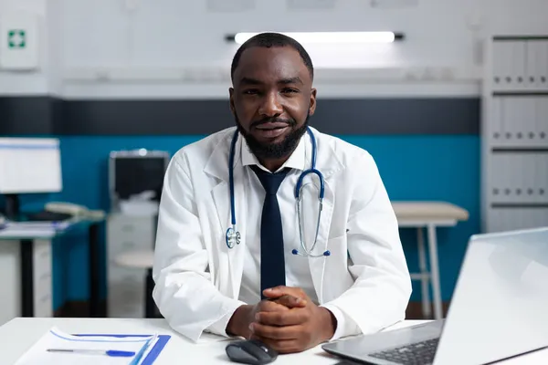 Retrato de médico praticante afro-americano trabalhando em consultório hospitalar — Fotografia de Stock