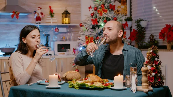 Par äter mat vid festlig middag och klinkande glasögon — Stockfoto