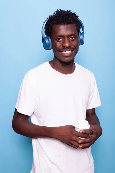 Mężczyzna noszący słuchawki podczas uśmiechu i patrząc w kamerę — Zdjęcie stockowe