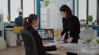 Kadınlar toplantı brifinginde iş arkadaşlarıyla konuşuyor.