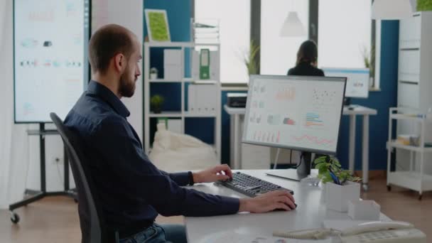 Портрет бизнесмена, работающего за компьютером в офисе — стоковое видео