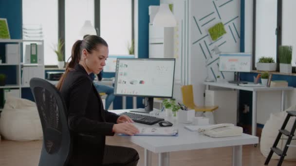 Affärskvinna som arbetar med dator- och datablad på papper — Stockvideo