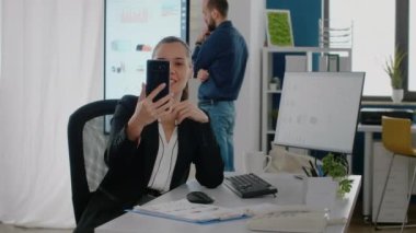 Girişimci video konuşması için akıllı telefonu tutuyor