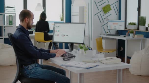 Hombre usando el ordenador y el teclado para trabajar con gráficos — Vídeos de Stock