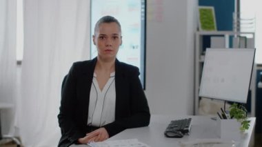 Ofiste masa başında oturan iş kadını portresi.
