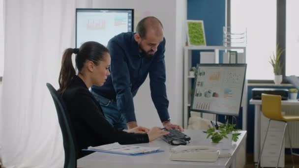 Homme et femme travaillant sur un plan d'affaires avec des graphiques de données — Video