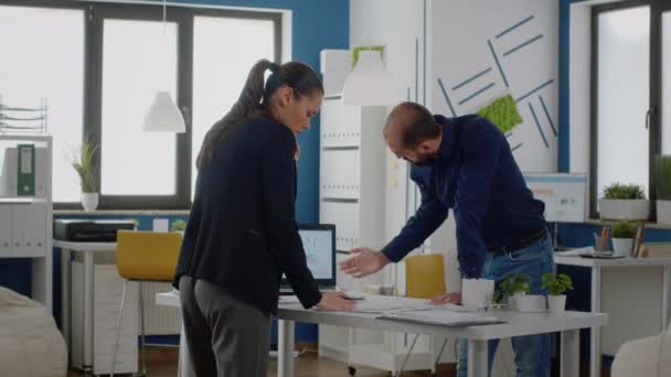 Чоловік і жінка використовують діаграми на ноутбуці для планування стратегії — стокове відео
